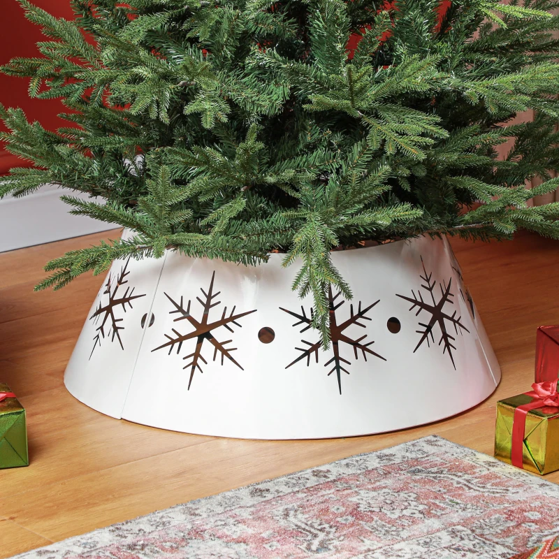 White metal Christmas tree collar with hollow snowflake cutouts under a green festive tree.