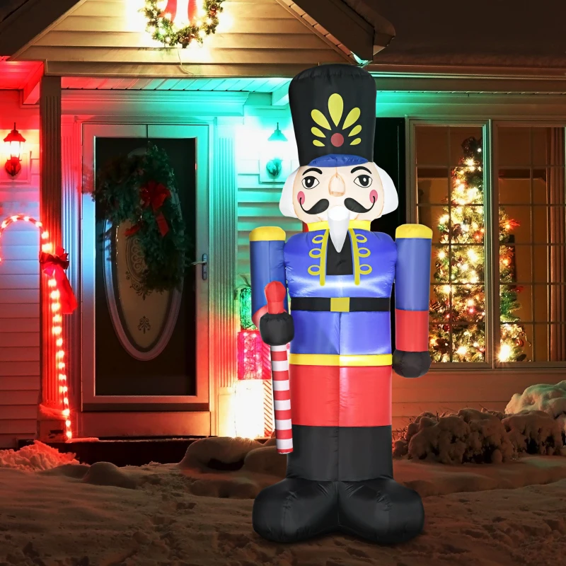 Giant inflatable nutcracker soldier with candy cane staff outside decorated home
