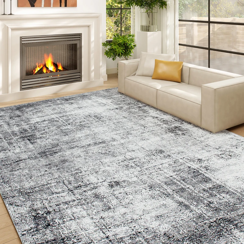 Large grey abstract patterned rug placed in cozy living room with fireplace