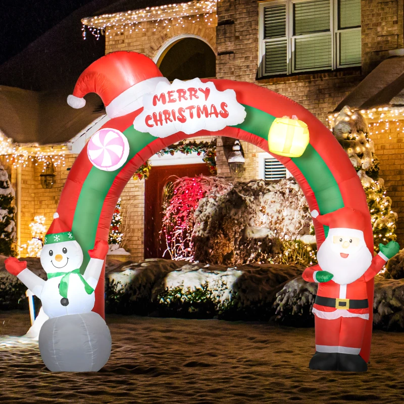 Inflatable snowman and Santa arch in snowy decorated yard