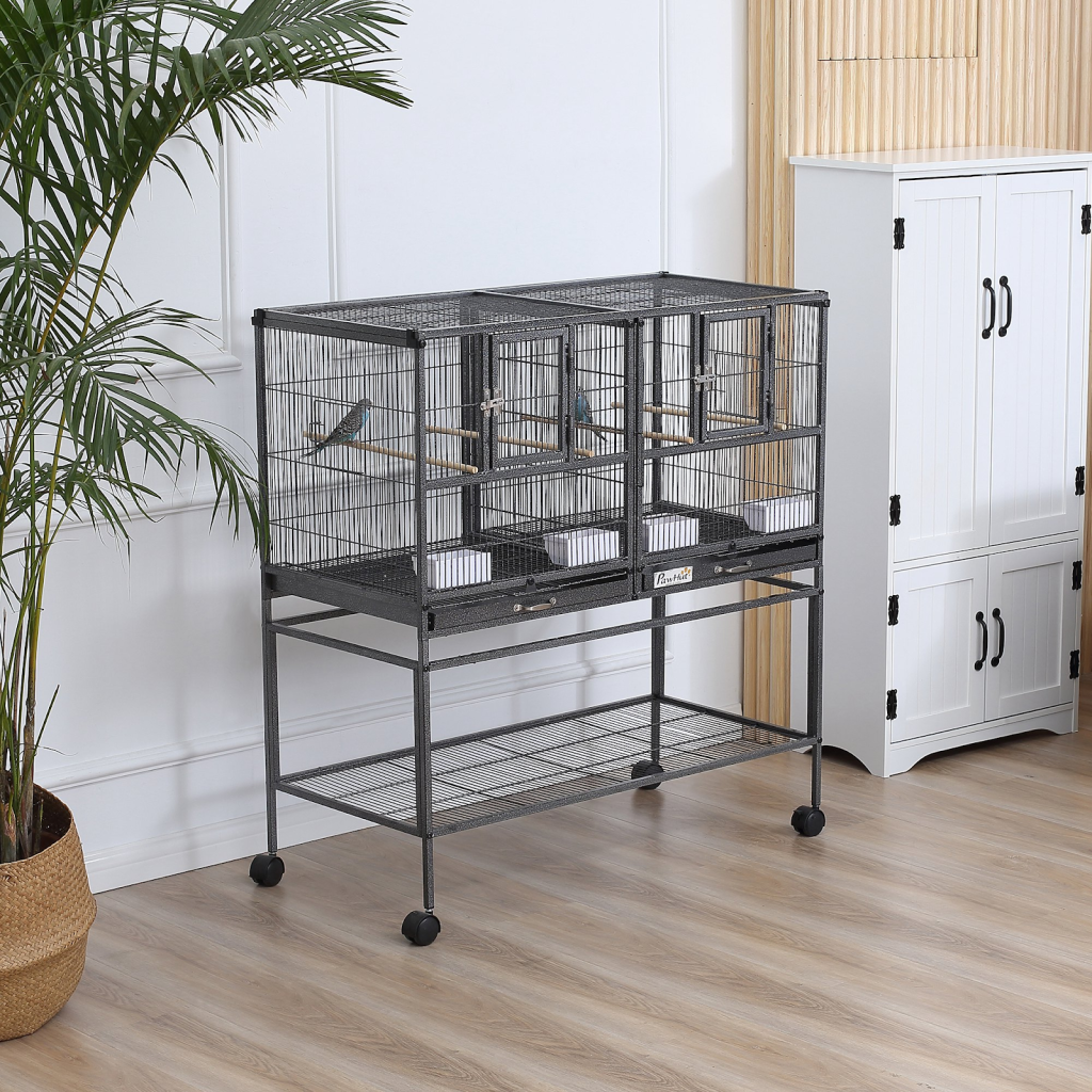 Double-section rolling bird cage with small birds inside.