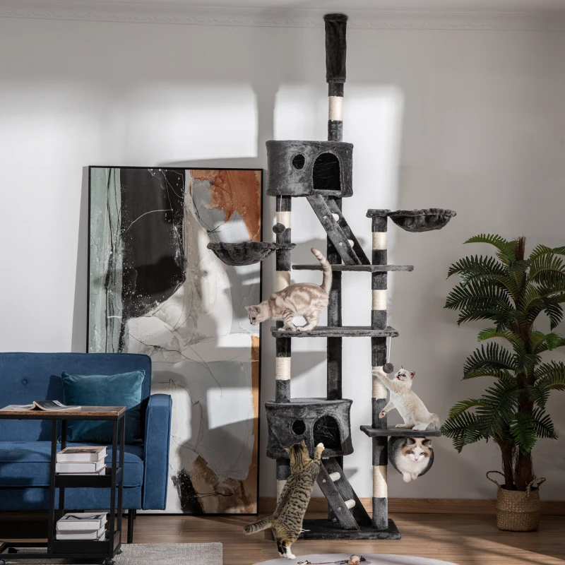 Large multi-level cat tree with several cats climbing, playing, and lounging in a bright living room.