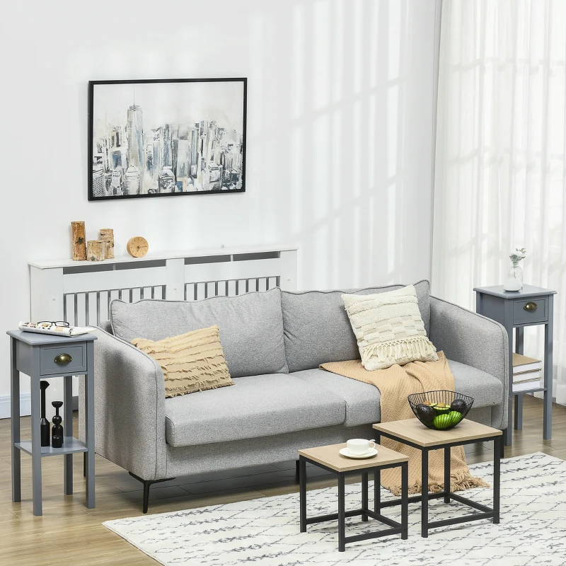 Grey narrow side tables beside grey sofa in bright living room.