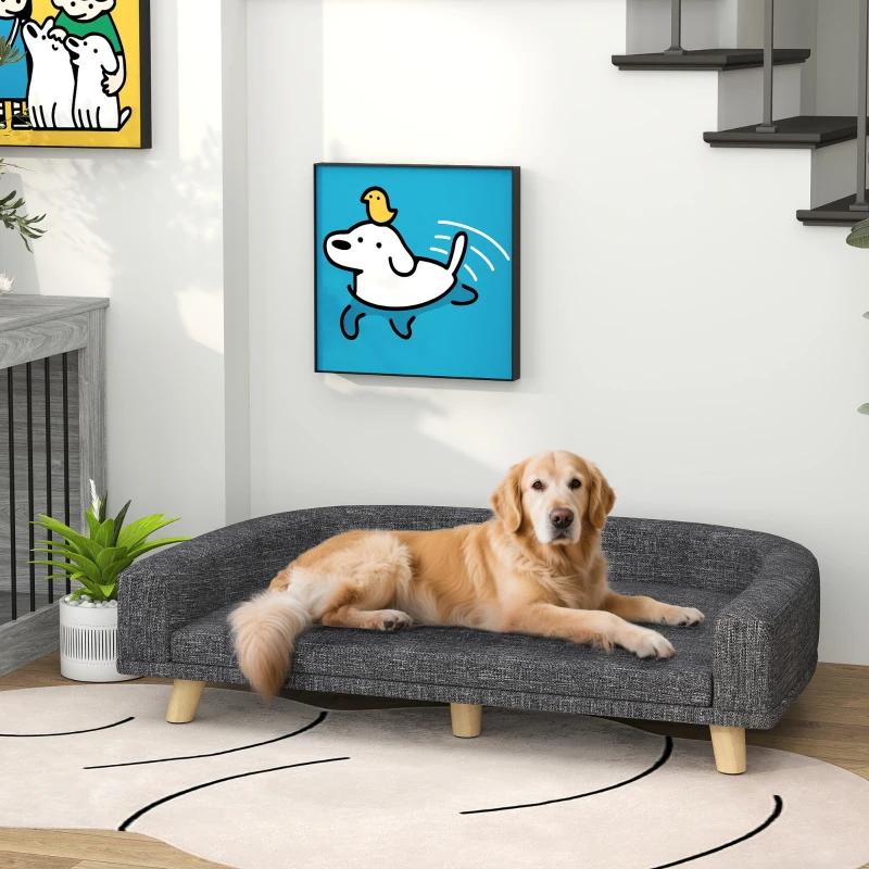 Golden retriever resting comfortably on a grey dog sofa in a bright modern room.