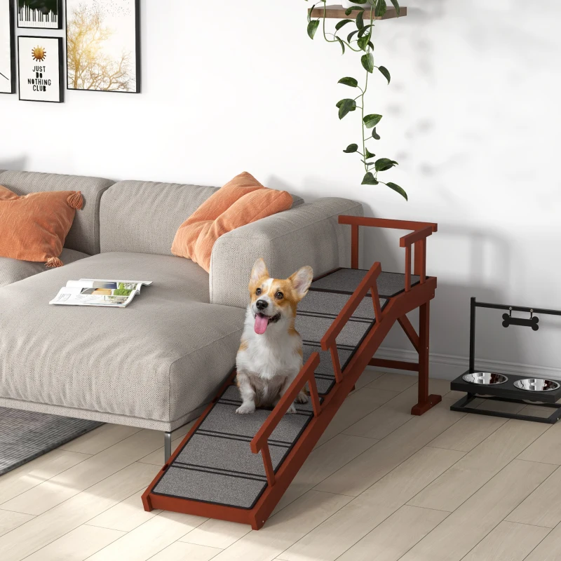  Happy corgi sitting on a wooden dog ramp beside a sofa in a modern living room.