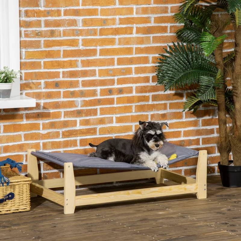 Dog comfortably resting on an elevated dog bed made with a durable pine wood frame.