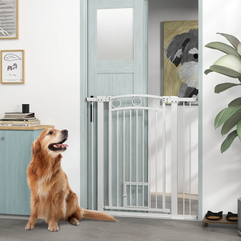 White extra-tall pet gate with cat door separating large golden dog from hallway.
