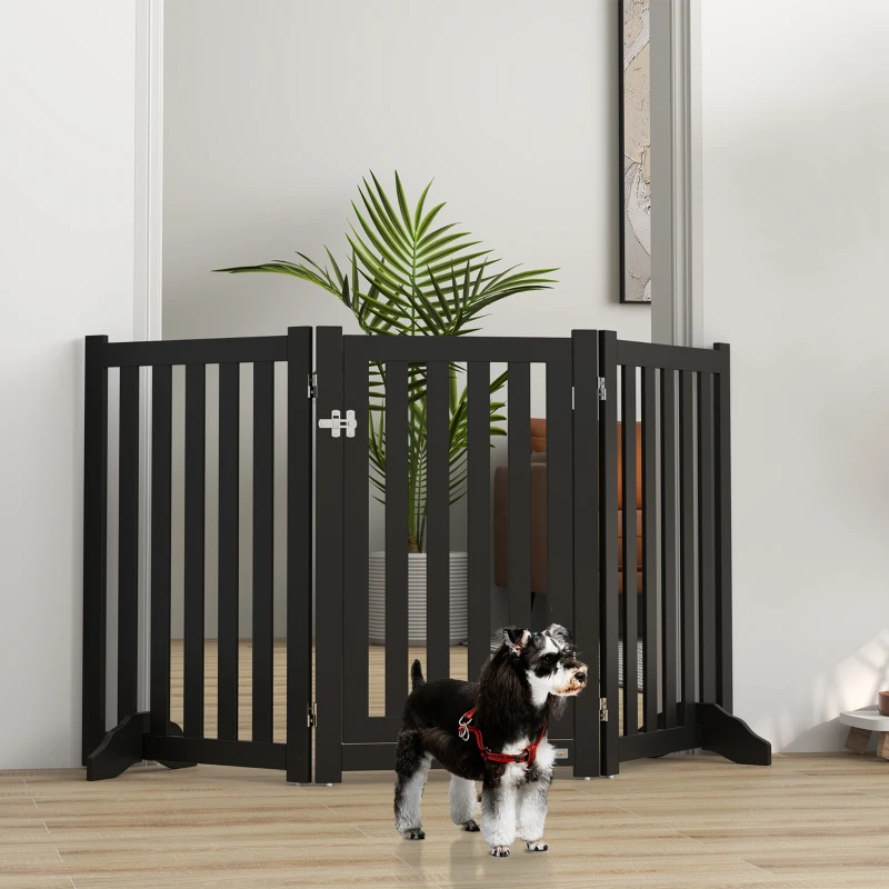 Mini Schnauzer beside tall black foldable freestanding dog gate with latch design.