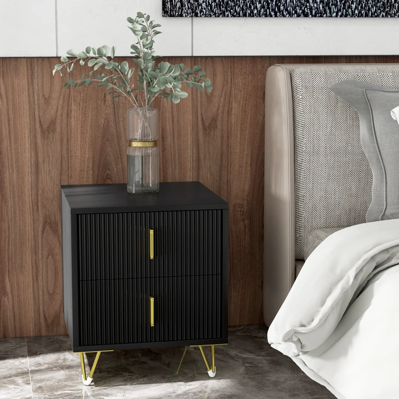 Black modern nightstand with gold handles beside bed and wood wall.
