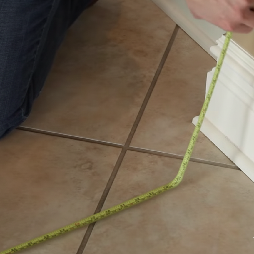 Measuring doorway width with a tape measure to ensure correct pet gate fit.