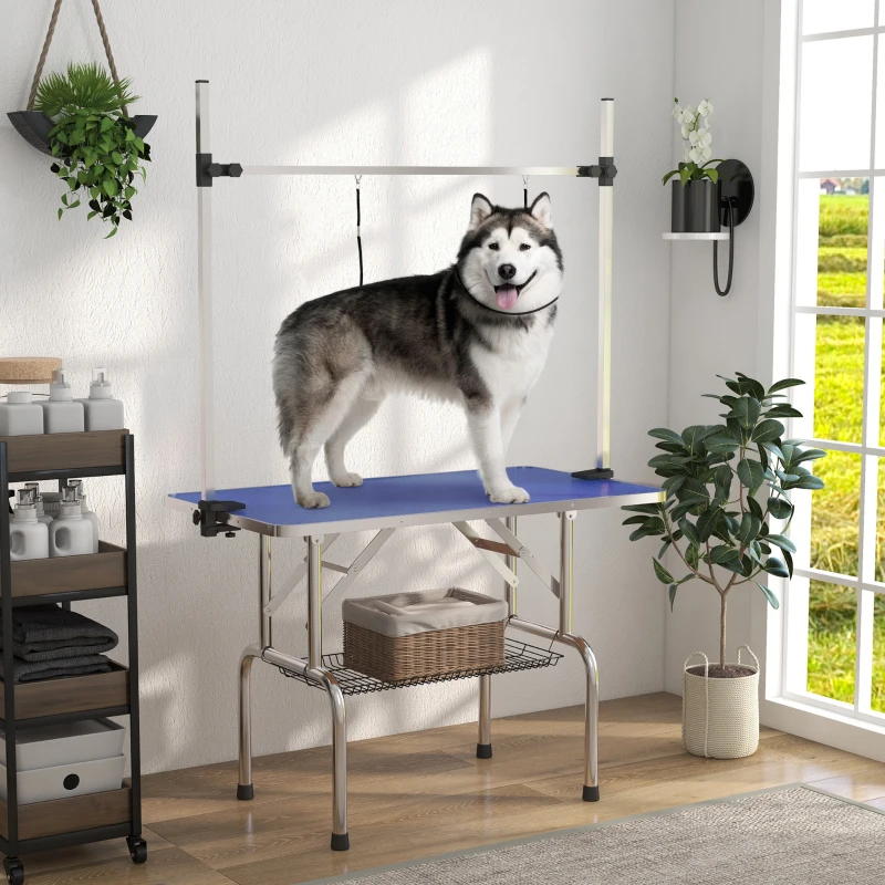 Dog grooming table with blue top, dual slings, mesh storage, and a Husky.
