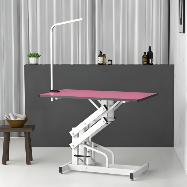 Pink electric grooming table set up in modern grooming room.