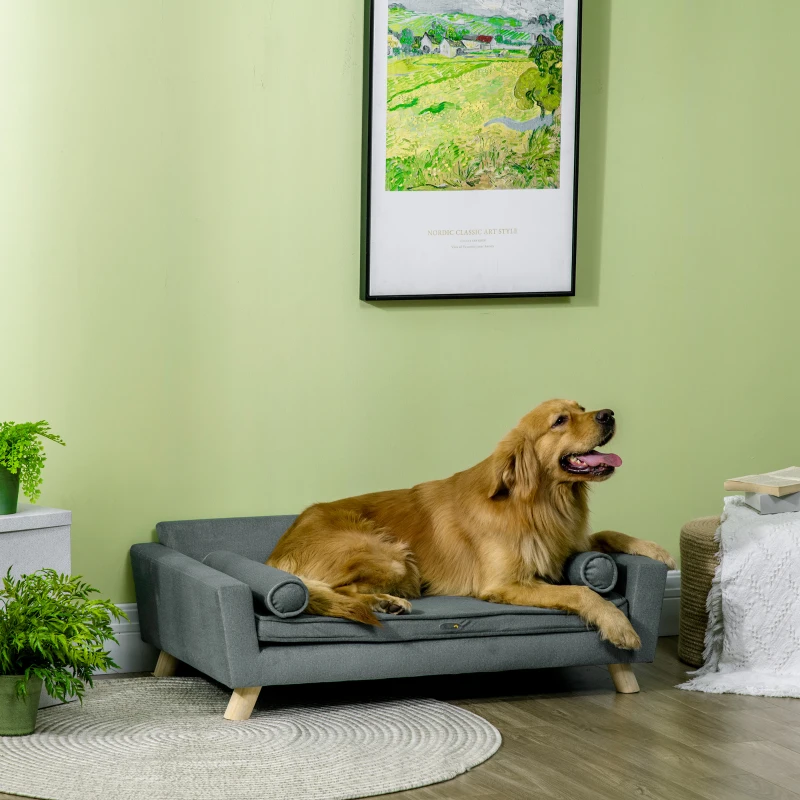 Golden retriever lounging on a large grey dog sofa in a bright green-themed room.