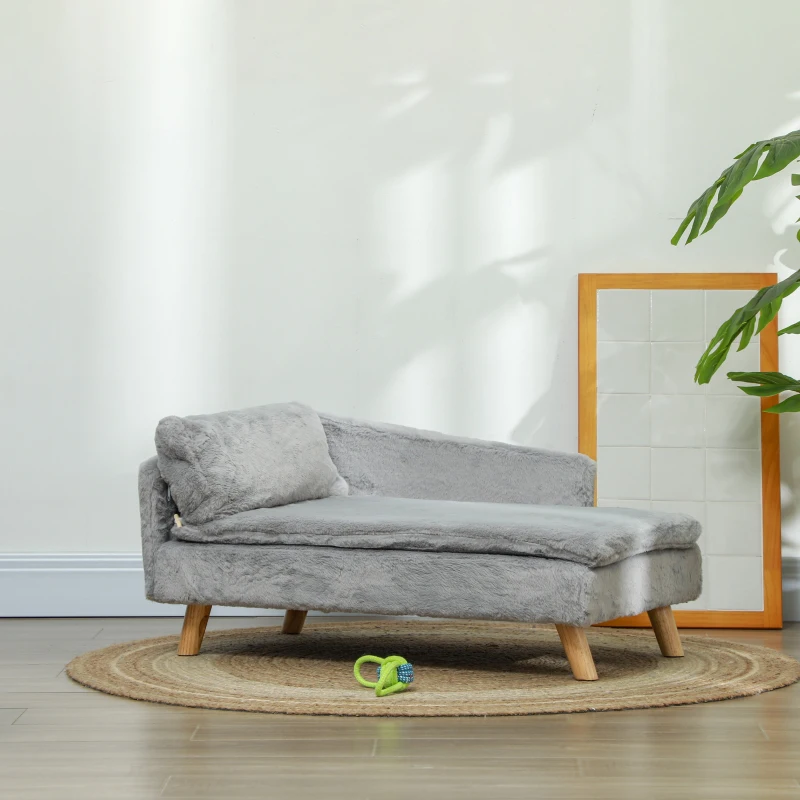 Medium-sized dog lying on a round grey elevated dog sofa in a bright room.