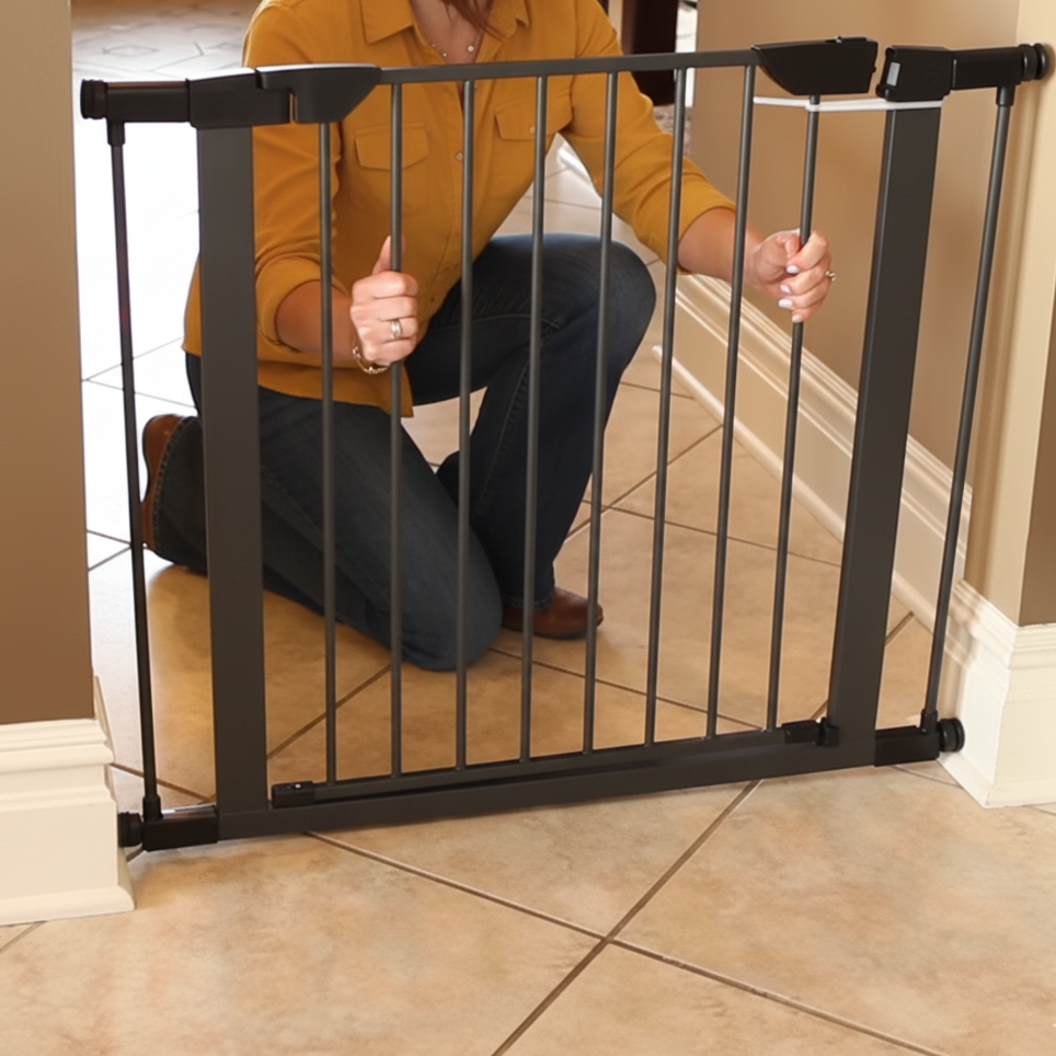 Aligning and positioning a black metal pet gate in a doorway before securing it.