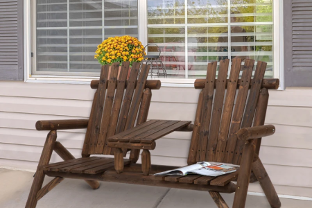 Photo of assembled wooden Adirondack double chair with center table placed on a patio.