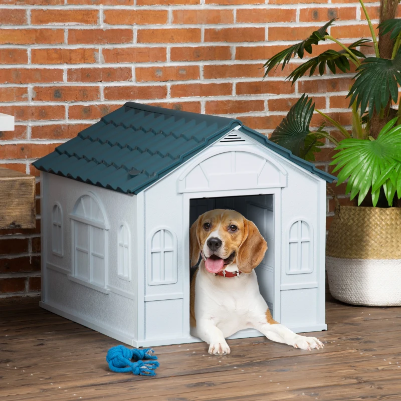 Beagle resting inside a plastic dog house with open door.