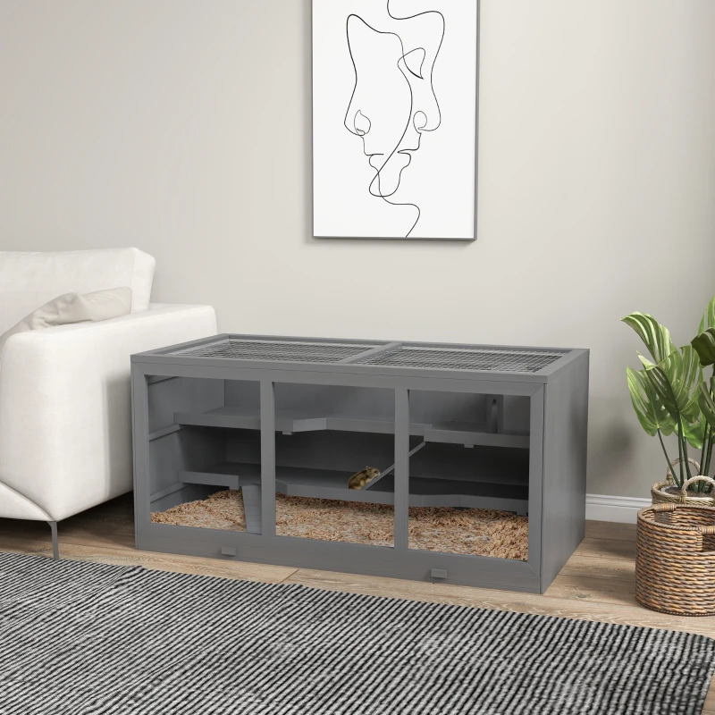 Large grey hamster cage setup beside sofa in living room.