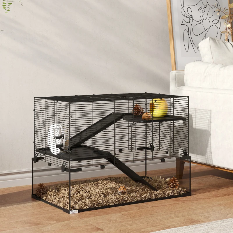 Wire hamster cage with wheel, ramps, chew toys, and bedding on a living room table.