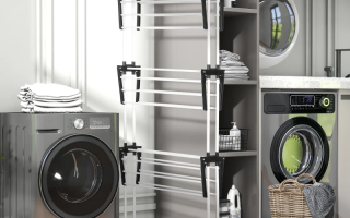 Foldable clothes drying rack placed in a laundry room beside washer and shelves.