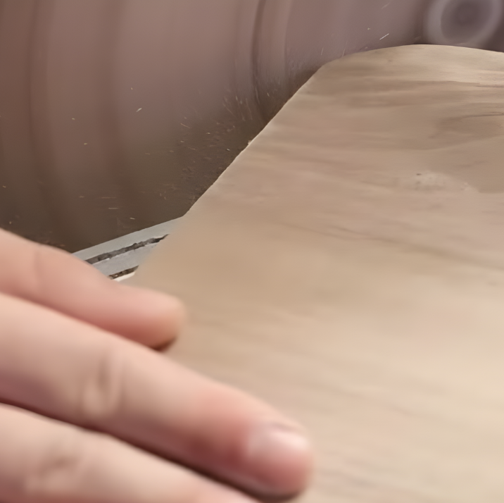 Sanding the edges of the wooden dog bed frame to smooth out sharp corners.