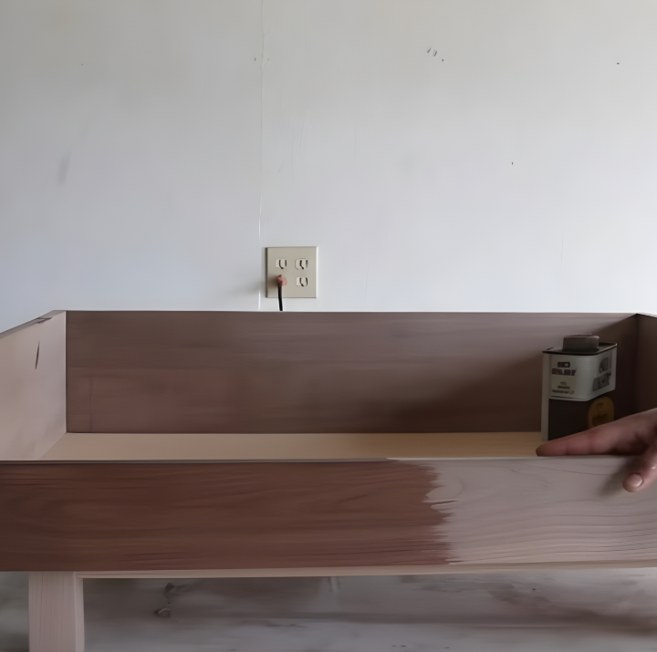 Sanding the edges of the dog bed frame before applying a protective finish.