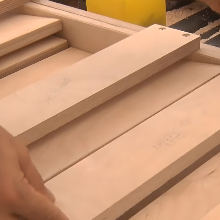 Person attaching wooden stair tread onto foldable dog stair structure during assembly.