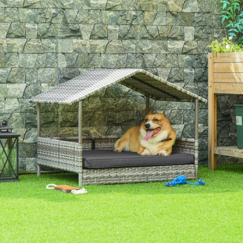 Corgi relaxing on outdoor wicker dog bed under a shaded roof.